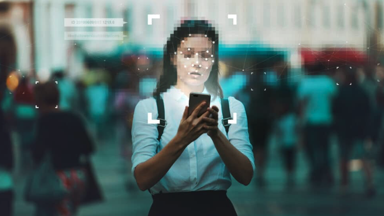 Girl with face blurred holding a mobile with a biometric scanner placed over face